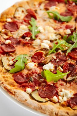 Biberli pizza dilimleri ve tabakta roka. Geleneksel İtalyan mutfağı, lezzetli fast food. Beyaz arka planda salam ve peynirli tuzlu yemek. Tabakta lezzetli pizzacı yemeği