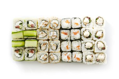 Beyaz arkaplan üst görünümüne ayarlayın. Lezzetli suşi, Asya mutfağı, sağlıklı beslenme, yakın çekim. Geleneksel Japon yemeği, pilav ve salatalık süslemeli balık yemeği, restoran yemeği.