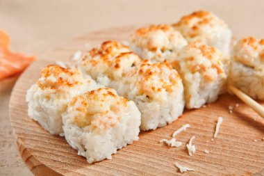 Ahşap tahta manzaralı fırınlanmış karides ruloları. Lezzetli sıcak suşi, soya soslu somon filetosu ve sashimi. Asya yemekleri, geleneksel Japon yemekleri, çubuklu deniz ürünleri.