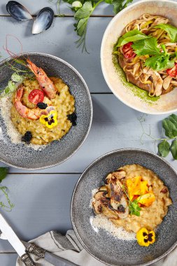 Seramik kaselerde risotto ve erişte. Et ve deniz ürünleri ile yükseltin, tavuklu makarna. Lezzetli şarküteriler, İtalyan ve Asya mutfağı yemekleri, restoran yemekleri.