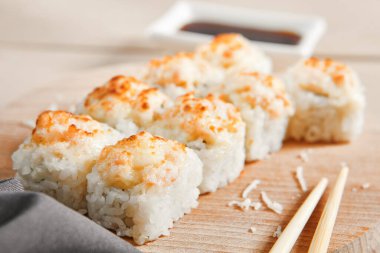 Ahşap tahta manzaralı fırınlanmış karides ruloları. Lezzetli sıcak suşi, soya soslu somon filetosu ve sashimi. Asya yemekleri, geleneksel Japon yemekleri, çubuklu deniz ürünleri.