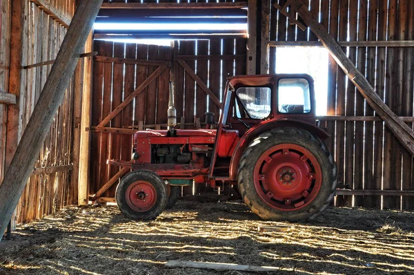 Red tractor in barn — Stock Photo, Image