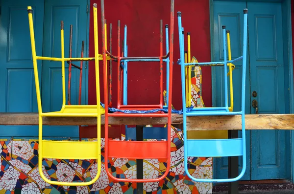 Sillas coloridas en una mesa de madera — Foto de Stock