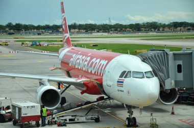 Unloading of baggage from the Air Asia aircraft clipart