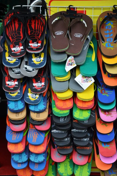 Kleurrijke slippers hangen af van de straatkant — Stockfoto