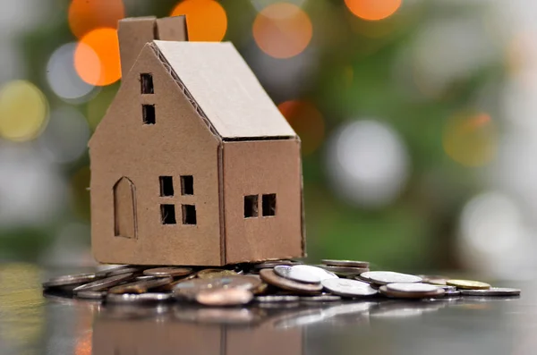 Modelo de casa com moedas na mesa de madeira — Fotografia de Stock