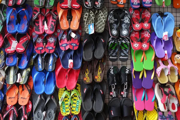 Kleurrijke slippers hangen af van de straatkant — Stockfoto