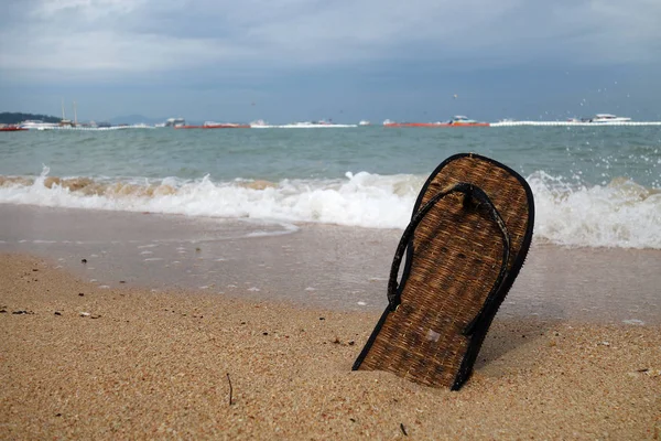 Zapatillas de playa en una playa de arena — Foto de Stock