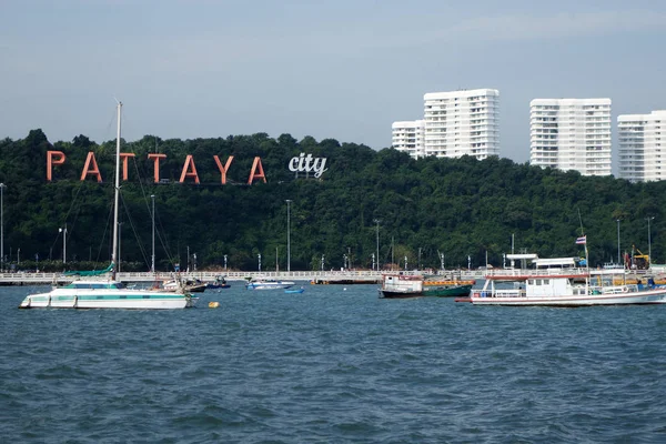 Паттайя залив с коммерческими лодками и знак города Паттайя — стоковое фото