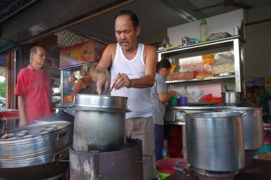 Street vendor with his noodle stall in Penang, Malaysia. clipart