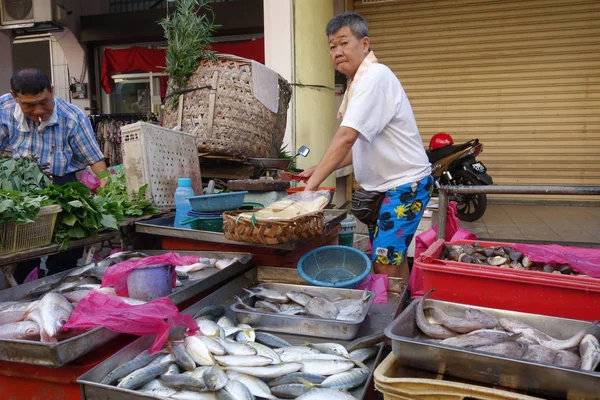 Unidentified seller sell fresh raw fish at local fish market in — Stock Photo, Image