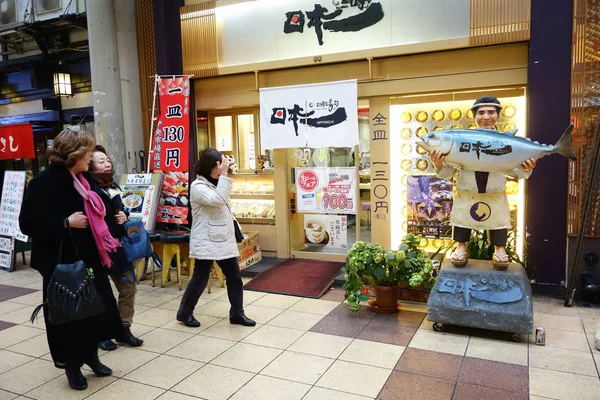 不明の人が散歩を渡す大阪道頓堀の寿司屋. — ストック写真
