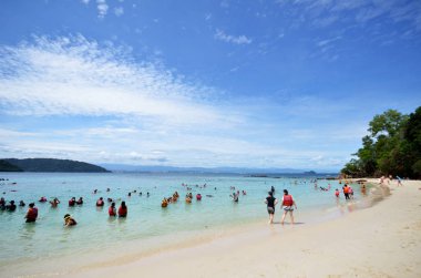 Turistler Sabah Island'da sapı beyaz kum plaj keyfini çıkarın