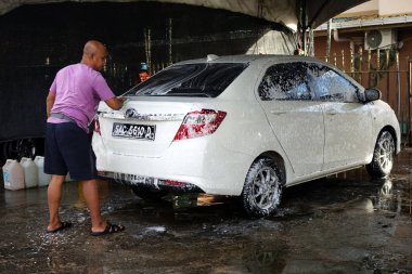 Worker washing the sedan car clipart