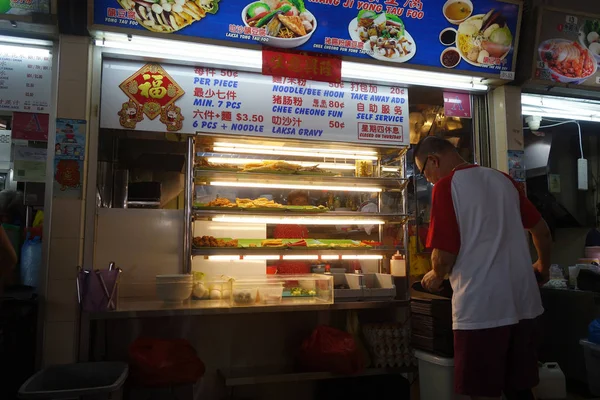 Vendedor preparando comida en su tienda en el centro de vendedores ambulantes en Singapur —  Fotos de Stock