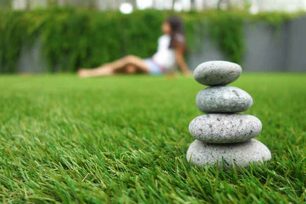 Pebbles stacked up on grass — Stock Photo, Image