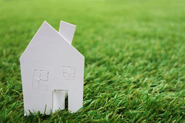 Paper house against on green grass — Stock Photo, Image