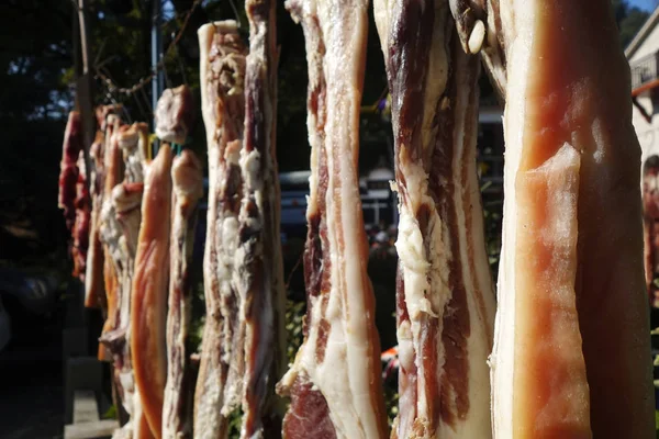 Подвешенные кусочки мяса сушат снаружи — стоковое фото