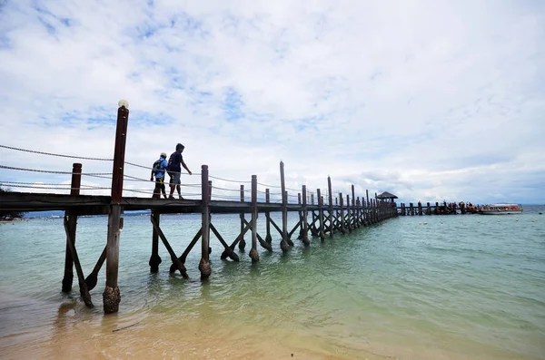 Туристы ходят по пешеходному мосту острова Манукан в Малайзии — стоковое фото