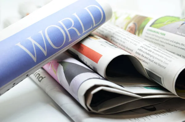 Walcowane gazety z world news — Zdjęcie stockowe