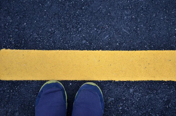 黄色の線でアスファルト地面の上に立って — ストック写真