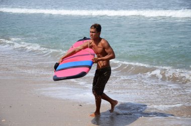 Deniz kıyısında sörf yapan mutlu sörfçüler