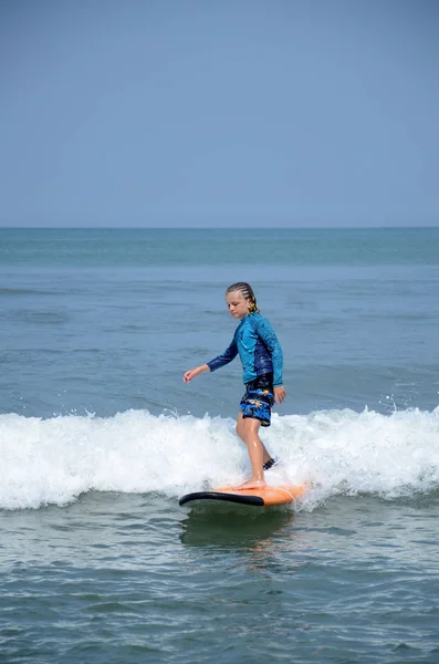 Jovem surfista passeio na prancha de surf com diversão nas ondas do mar em Bali isl — Fotografia de Stock