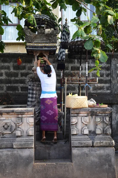 Una mujer rezando en un templo fuera de la calle en Bali Indonesia . —  Fotos de Stock