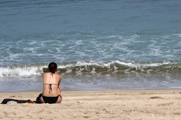 Zadní pohled na sexy ženu v bikinách sedí na bílém písku tropické — Stock fotografie