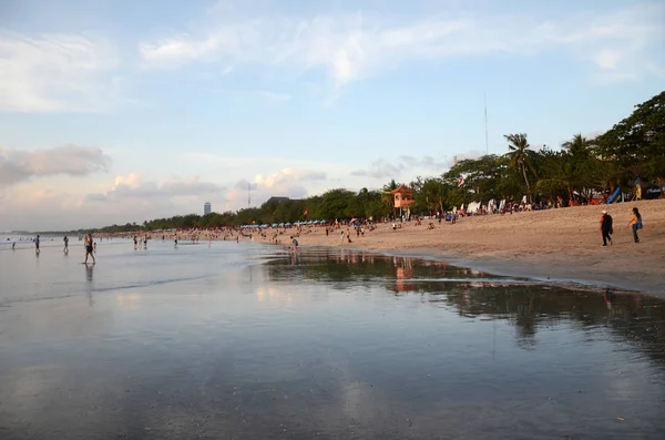 Les gens apprécient le coucher de soleil spectaculaire sur la plage de Kuta, Bali — Photo