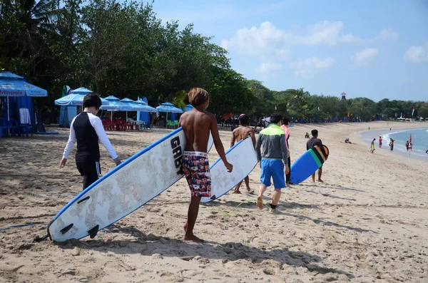 Surfistas felizes com pranchas de surf ao longo da costa do mar indo para o — Fotografia de Stock