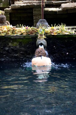 Pura Tirta Empul 'daki kutsal havuzun kutsal kaynak suyunda dua ediyorum. 