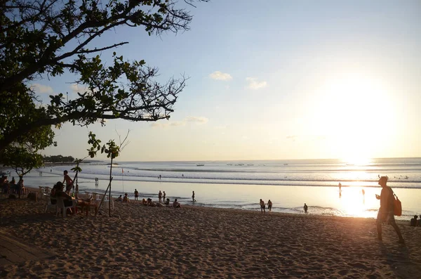 La gente si gode il drammatico tramonto sulla spiaggia di Kuta, Bali — Foto Stock