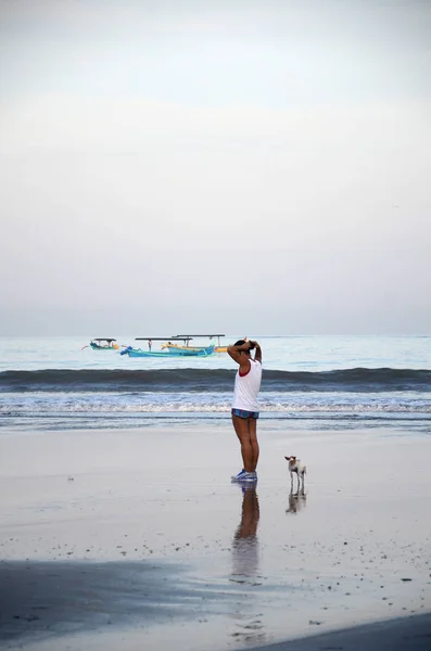 Žena se psy procházky na tropické pláži v dopoledních hodinách na Bali — Stock fotografie