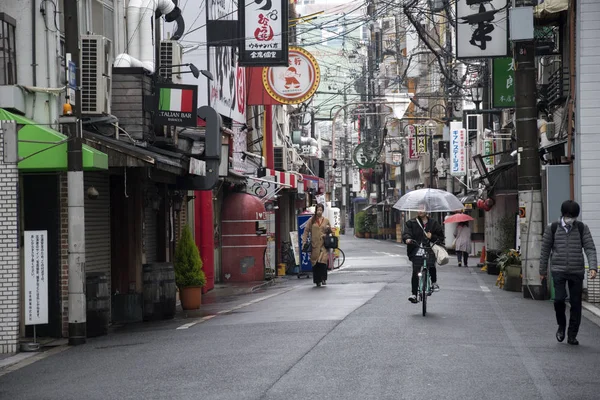 Ludzie z parasolkami na mokrej ulicy w deszczowe dni w Osace, Ja — Zdjęcie stockowe