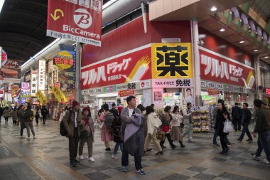 Gece vakti Dotonburi caddesinde yürüyor.