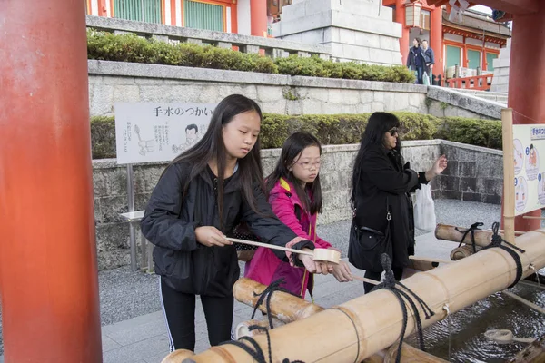 Les touristes se lavent les mains au pavillon de lavage des mains à Fushimi In — Photo
