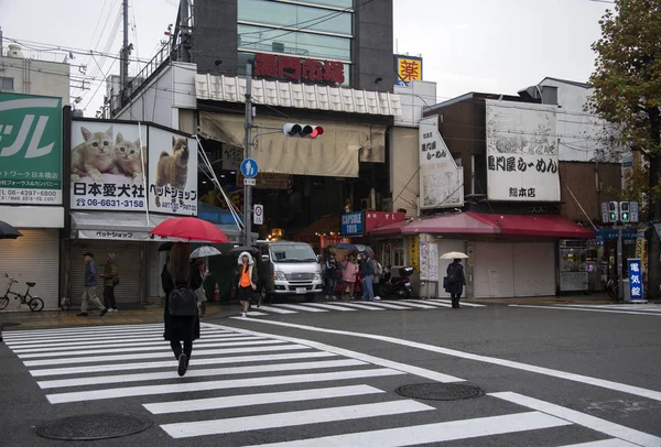 Turistas y viajeros caminando hacia el mercado de pescado Kuromon en —  Fotos de Stock