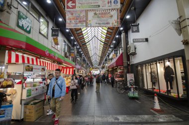 Müşteriler Osaka Japonya 'daki Nipponbashi Kuromon Ichiba pazarını ziyaret ediyorlar
