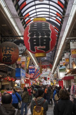 Müşteriler Osaka Japonya 'daki Nipponbashi Kuromon Ichiba pazarını ziyaret ediyorlar