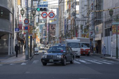 İnsanlar Osaka Japonya 'da trafikte araba kullanırlar.