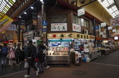 Müşteriler Osaka Japonya 'daki Nipponbashi Kuromon Ichiba pazarını ziyaret ediyorlar