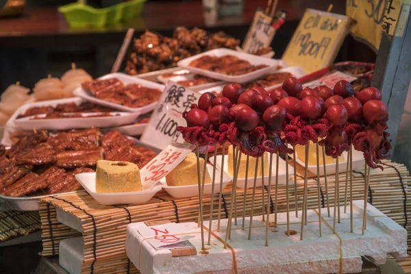 Шашлыки из осьминога продаются на рынке Куромон в Осаке, Япония — стоковое фото