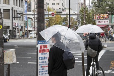 Osaka, Ja 'da yağmurlu bir günde ıslak sokakta şemsiyeli insanlar.