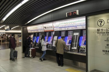 People buying tickets at railway station in Osaka, Japan