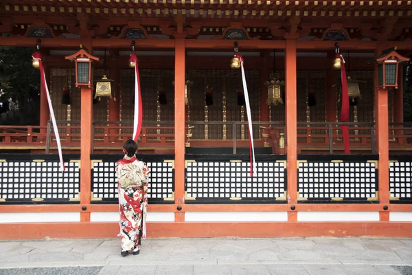 Geisha ragazza indossando kimono giapponese tra rosso in legno Tori Gate — Foto Stock