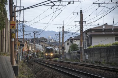 Sagano yerel treni sonbaharda Arashiyama 'dan geçer.