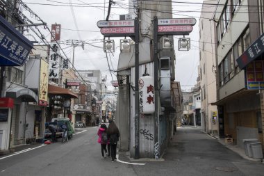 İnsanlar sabah Namba bölgesinde sessiz caddelerde yürüyorlar.