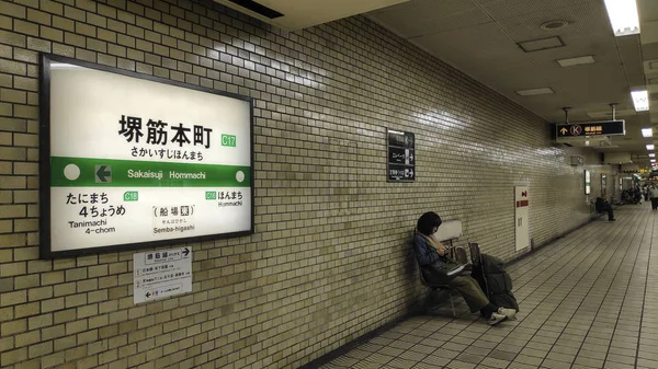 Пасажир чекає поїзд на платформах Sakaisuji Hommachi. — стокове фото
