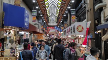 Müşteriler Osaka Japonya 'daki Nipponbashi Kuromon Ichiba pazarını ziyaret ediyorlar